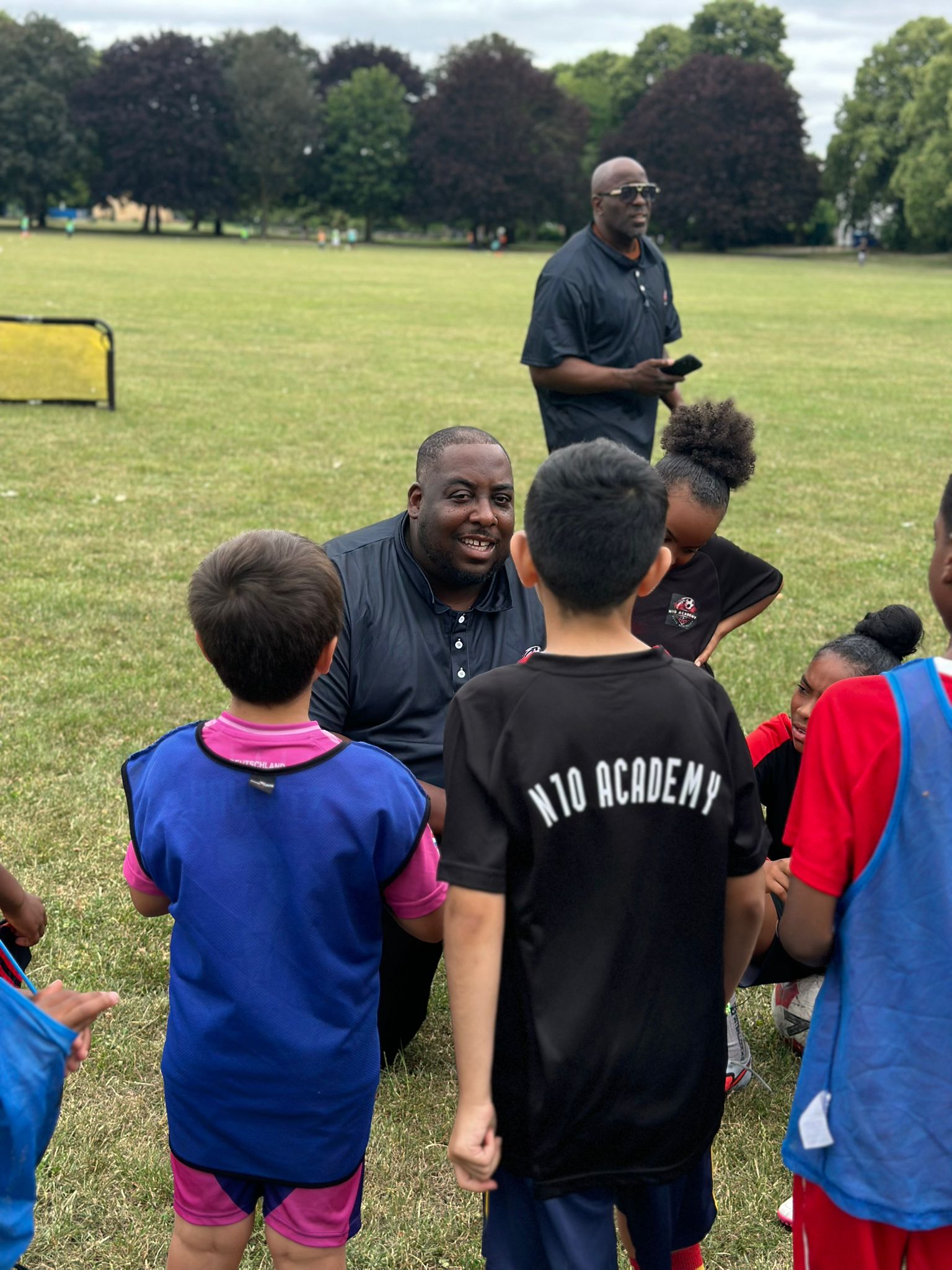 N10 Academy coach talking with a group of young players after a session